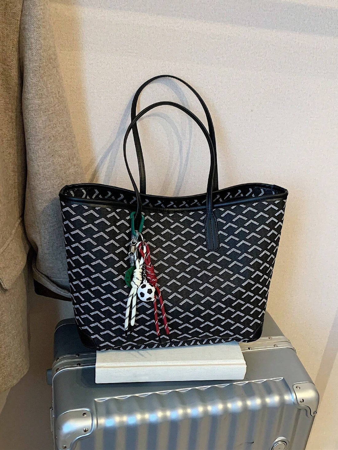 Torebka GeoLuxe w kolorze zielonym na stole z książkami