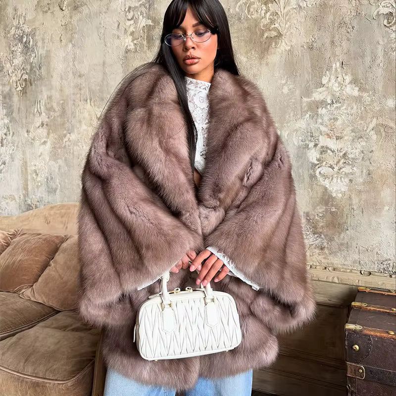 kobieta w jasnobrązowym płaszczu ze sztucznego futra z białą torebką i jeansami